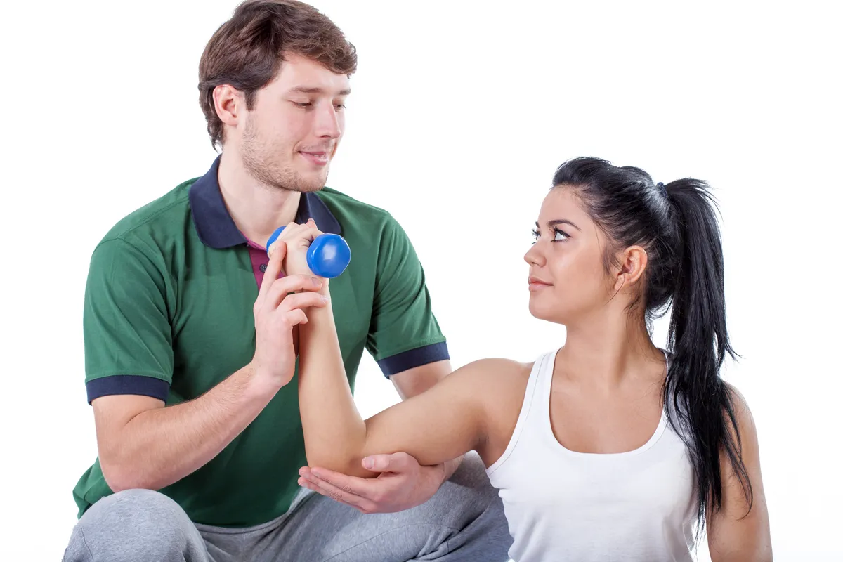 Young physiotherapist doing elbow exercises with his patient